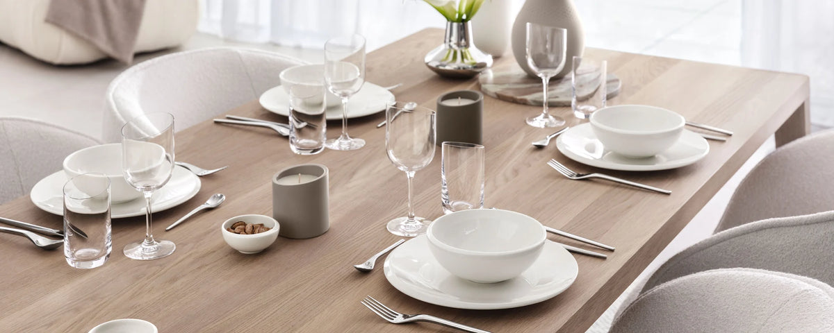 A Villeroy & Boch NewMoon formal table setting with candles on a wooden table