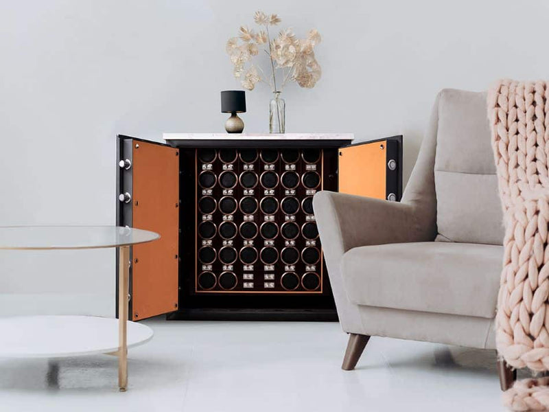 An Orient Crown watch winder cabinet, doors open, styled in a bright modern living room